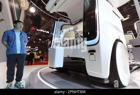 Schanghai. 18. April 2023. Ein Besucher bestaunt ein autonomes Fahrzeug von Didi auf der Shanghai International Automobile Industry Exhibition 20. in Schanghai im Osten Chinas am 18. April 2023. Die Shanghai International Automobile Industry Exhibition 20. begann am Dienstag im National Exhibition and Convention Center (Shanghai), wo viele Autohersteller ihre neuen, energiesparenden und intelligenten vernetzten Fahrzeuge unter dem Trend zum umweltfreundlichen und kohlenstoffarmen Verbrauch präsentieren. Kredit: Fang Zhe/Xinhua/Alamy Live News Stockfoto