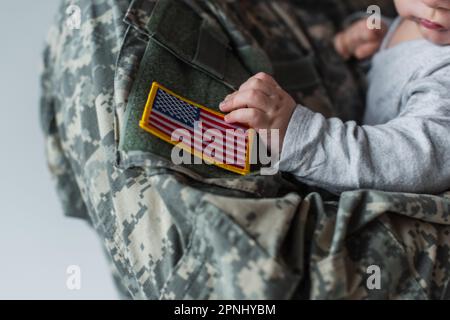 Schnittbild eines amerikanischen Soldaten in Uniform im grau isolierten neugeborenen Jungen Stockfoto
