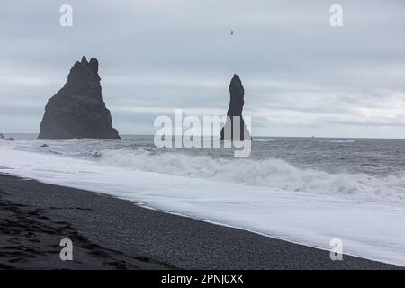 Stürmischer, stimmungsvoller Tag am schwarzen Sandstrand Reynisfjara in Island mit großen Wellen des Atlantischen Ozeans Stockfoto