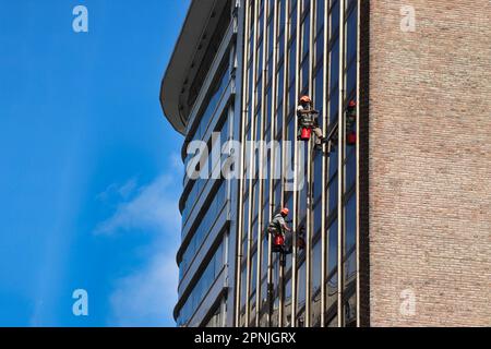 Zwei Männer putzen die Fenster eines Gebäudes in buenos aires Stockfoto