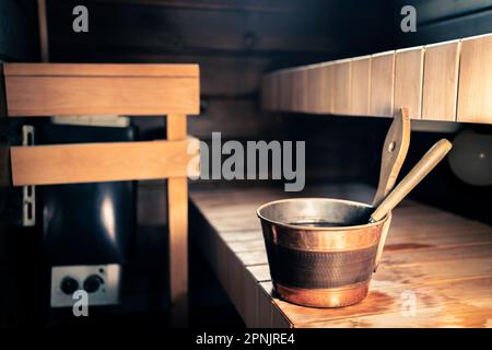 Sauna, Wellness-Dampfbad in Finnland. Sommerkabine aus Holz. Elektroherd im Stadthaus oder Hotel. Kelle und Wassereimer. Gesundheitsbad. Stockfoto