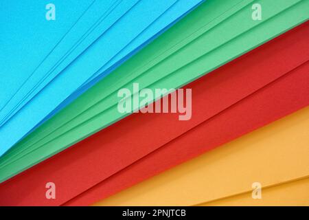 Ein Hintergrund aus gelbem, rotem, grünem und blauem Papier. Schließen. Stockfoto