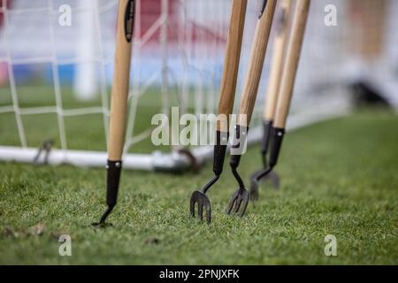 Nahaufnahme des Sportplatzes/der Spielfeldpflege und der Bodengeräte, die aufrecht im Gras auf dem Fußballplatz stehen. Stockfoto