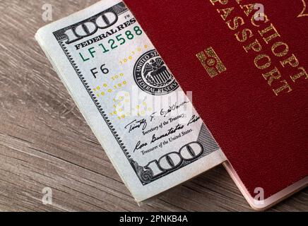 Ein russischer Pass mit einem Haufen Dollar. Das Konzept einer Reise. Umzug Stockfoto