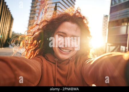 Nicht binäres Geschlecht Person posiert fröhlich Foto draußen. Neue Generationen und jugendlicher Lebensstil. Stockfoto