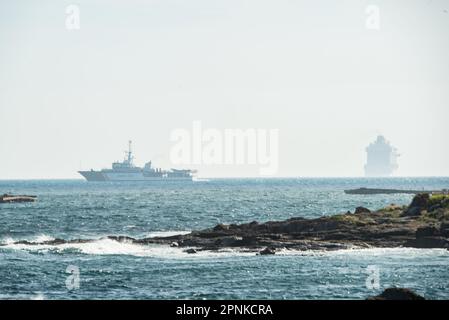 Vigo, Spanien. April 19., 2023. Das luxuriöse Kreuzfahrtschiff Britannia von southampton segelt in den Südkanal der Bucht von Vigo und setzt Kurs nach lissabon mit seiner 330 Meter Länge und seinen fast 7000 Passagieren und der Besatzung an Bord. Das Schiff wurde von zwei Patrouillenbooten der staatlichen Sicherheitskräfte auf die Cies-Inseln begleitet. Kredit: Xan Gasalla / Alamy Live News. Stockfoto