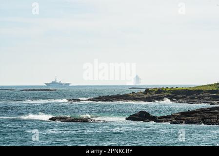 Vigo, Spanien. April 19., 2023. Das luxuriöse Kreuzfahrtschiff Britannia von southampton segelt in den Südkanal der Bucht von Vigo und setzt Kurs nach lissabon mit seiner 330 Meter Länge und seinen fast 7000 Passagieren und der Besatzung an Bord. Das Schiff wurde von zwei Patrouillenbooten der staatlichen Sicherheitskräfte auf die Cies-Inseln begleitet. Kredit: Xan Gasalla / Alamy Live News. Stockfoto