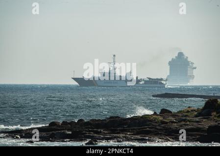 Vigo, Spanien. April 19., 2023. Das luxuriöse Kreuzfahrtschiff Britannia von southampton segelt in den Südkanal der Bucht von Vigo und setzt Kurs nach lissabon mit seiner 330 Meter Länge und seinen fast 7000 Passagieren und der Besatzung an Bord. Das Schiff wurde von zwei Patrouillenbooten der staatlichen Sicherheitskräfte auf die Cies-Inseln begleitet. Kredit: Xan Gasalla / Alamy Live News. Stockfoto