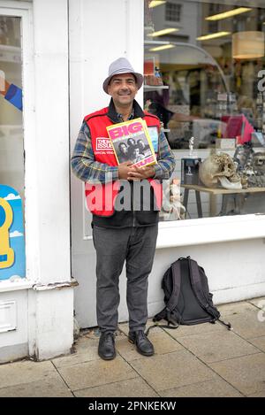 Große Ausgabe. Straßenhändler, der das Magazin "Big Issue" zur Unterstützung der Obdachlosen und arbeitslosen Bevölkerung Großbritanniens verkauft. England Großbritannien Stockfoto