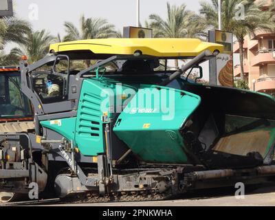 Kairo, Ägypten, April 18 2023: Asphaltfertiger mit Kettenlaufwerk, Ein Asphaltfertiger (Straßenfertiger, Asphaltfertiger, Straßenpflastermaschine) ist ein Bauwerk Stockfoto