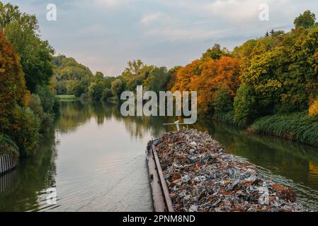 Transportindustrie. Ein Schiff transportiert Metallschrott und Sand mit Kies. Ein mit Metallschrott beladener Kahn ist auf der Straße. Metallschrott Stockfoto