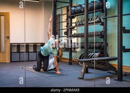 Junge Dame im Studio, Physiotherapie-Sitzung mit Stretching-Training Stockfoto