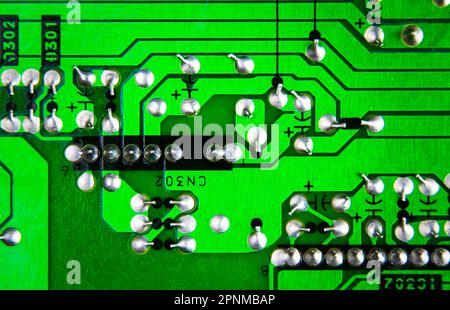 Nahaufnahme einer grünen elektronischen Leiterplatte mit Pinlöten nach Industriestandard, elektronisches Bauteilkonzept. Stockfoto