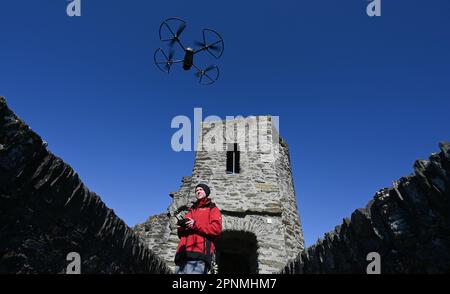 PRODUKTION - 05. April 2023, Hessen, Hohenstein: Werner Maziborsky von der Firma Linsinger ZT aus St. Johann im Pongau (Österreich) startet eine Drohne auf den Festungsmauern, um die Burgruinen Hohenstein in der Nähe von Bad Schwalbach im Taunus digital zu besichtigen. Der Landesbetrieb Bau und Immobilien Hessen (LBIH) hat am Kulturdenkmal im Aartal bereits einen großen Teil eines umfangreichen Renovierungsprojekts durchgeführt. Für die nächsten Restaurierungsschritte muss der Burgkomplex in diesem Frühjahr digital überprüft werden. (Zu dpa: 'Moderne Technologie trifft auf alte Mauern - Schlossbesichtigung mit der Drohne'. Foto: A Stockfoto