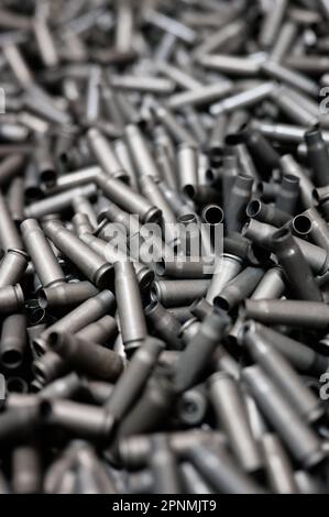 Geschosshüllen auf dunklem Hintergrund in der Rüstungsfabrik Stockfoto