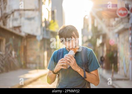 Ein Mann, der in Istanbul Street Food isst. Balik ekmek: Fisch in Brot, traditionelles türkisches Fast Food. Istanbul, Türkei Stockfoto