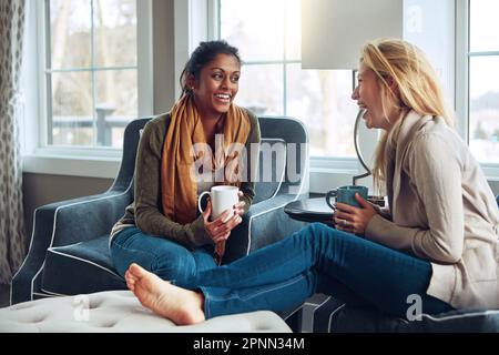 Zeit ist das, was ihre Freundschaft großartig macht. Zwei junge Frauen trinken zusammen Kaffee an einem entspannten Tag zu Hause. Stockfoto