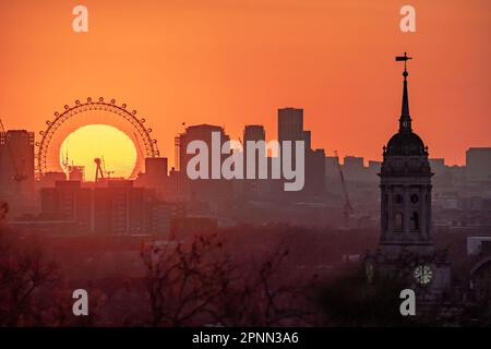 London, Großbritannien. 19. April 2023. UK Weather: Dramatische Abendsonne geht hinter dem Riesenrad des London Eye unter, vom Gipfel des Greenwich Park aus gesehen. Kredit: Guy Corbishley/Alamy Live News Stockfoto