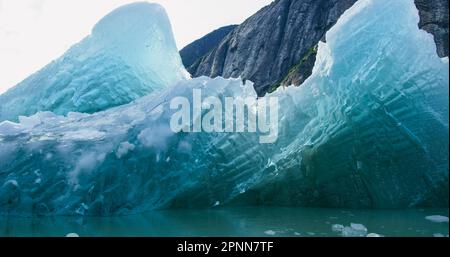 Beobachten Sie die Eisschollen und Eisberge auf dem Fluss in einem kleinen Boot. Felsen, Eis, Flüsse, Wälder und Berge: Die Sommerlandschaft von Alaska. Stockfoto