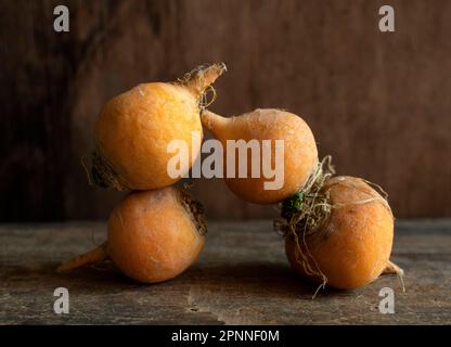 Gruppe von frischen, orangen Rüben auf einem rustikalen Holztisch Stockfoto