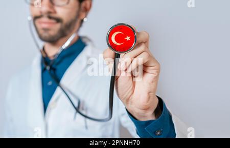 Arzt hält Stethoskop mit Truthahnfahne. Türkei Gesundheits- und Pflegekonzept, türkische Flagge auf Stethoskop Stockfoto