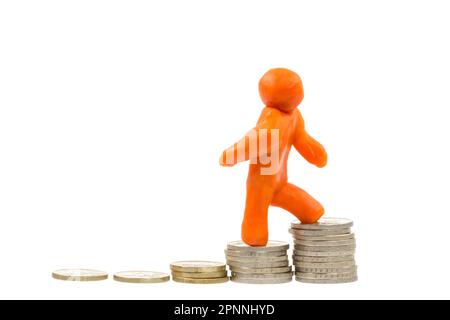 Aufstieg auf den Gipfel - Self-made menschlichen Plastilin Abbildung Klettern auf einen Stapel von Euro-Münzen Stockfoto