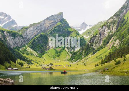 Zwei Musiker blasen das Alphorn in einem Boot, Seealpsee, Wasserauen, Kanton Appenzell Innerrhoden, Schweiz Stockfoto