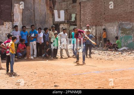 Cricket ist ein beliebter Sport in Indien, in allen Gesellschaftsschichten, Kinder, die in einem Hinterhof spielen, Dharavi, der größte Slum in Asien mit bis zu 600, 000 Stockfoto