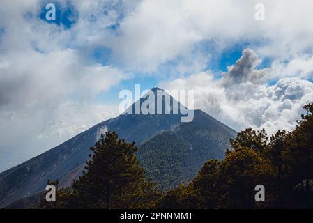 Der dramatische Blick auf den Vulkan El Fuego in Antigua, Guatemala, bedeckt von weißen Wolken Stockfoto