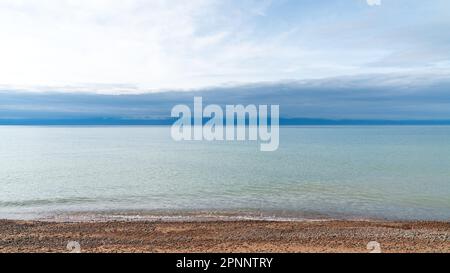 Landschaft des Sees Issyk Kul in Kirgisistan. Issyk Kul ist ein großer, hoch gelegener See, bekannt für sein kristallklares Wasser und ein beliebtes Touristenziel Stockfoto
