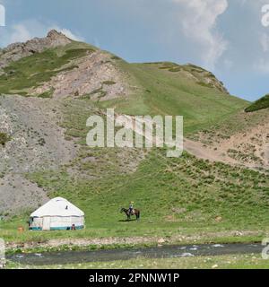 Kirgisistan - Mai 2022: Kinder in der Nähe eines traditionellen Jurtzelts in Kirgisistan. Jurtzelte sind traditionelle, tragbare Zelte aus Filz, die Sie sind Stockfoto