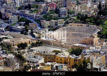 Ansicht der Stadt und des Römischen Theaters, Amman, Königreich Jordanien  Erhöhte Ansicht des Römischen Theaters in Amman, Jordanien, fotografiert von den Hügelruinen der Zitadelle von Amman mit der modernen Stadtlandschaft, die sich im Hintergrund ausbreitet. Amman, Jordanien (Römische Philadelphia) ist für die meisten ausländischen Besucher das Highlight von Amman. Das Theater selbst ist in die Nordseite eines Hügels geschnitten und bietet Platz für 6000 Zuschauer. 2. Jahrhundert n. Chr. während der Herrschaft von Antoninus Pius (138–161 n. Chr.) , Stockfoto