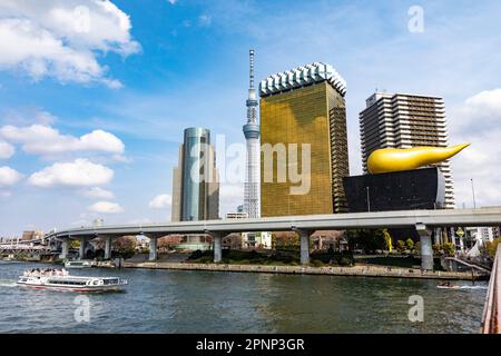 Sumida-Fluss Toky0. Das Flussboot passiert den höchsten Turm des Tokyo Sky Tree und die Asahi-Flamme, Bierhalle und Büros, April 2023, Japan, Asien Stockfoto