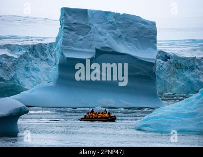 Mit dem Boot voller Touristen erkunden Sie riesige Eisberge, die in der Bucht in der Nähe der Arktis Ilulissat grönland und der antarktischen Halbinsel treiben Stockfoto