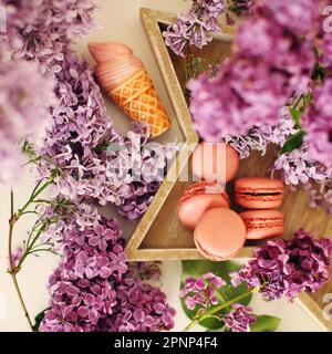 Verschiedene Makronen-Kekse mit Eiskrem und Fliederblüten Stockfoto