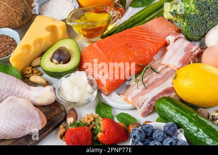 Keto-Diät-Konzept. Ketogene Diätkost. Ausgewogener kohlenhydratarmer Lebensmittelhintergrund. Gemüse, Fisch, Fleisch, Käse, Nüsse. Atkins-Diät Stockfoto