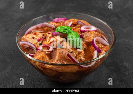 Rohes Schweinefleisch oder Rindfleisch in Marinade auf schwarzem Hintergrund. Kochen von grillgerichten oder Grillgerichten. Shashlik, Shish Kebab Stockfoto