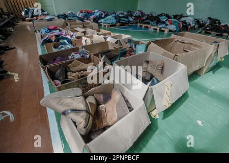 Kherson, Ukraine. 19. April 2023. Kisten mit humanitärer Hilfe, die im Unterschlupf in Kherson gesehen wurden. Obwohl die ukrainischen Streitkräfte russische Truppen aus der Stadt verdrängten und während der Befreiung Mitte November Jubelszenen auslösten, zogen sich die russischen Streitkräfte nur über den Fluss Dnipro zurück und schossen Kherson täglich weiter. Kredit: SOPA Images Limited/Alamy Live News Stockfoto