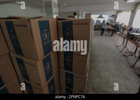 Kherson, Ukraine. 19. April 2023. Lebensmittelboxen für humanitäre Zwecke im Unterschlupf in Kherson. Obwohl die ukrainischen Streitkräfte russische Truppen aus der Stadt verdrängten und während der Befreiung Mitte November Jubelszenen auslösten, zogen sich die russischen Streitkräfte nur über den Fluss Dnipro zurück und schossen Kherson täglich weiter. (Foto: Aziz Karimov/SOPA Images/Sipa USA) Guthaben: SIPA USA/Alamy Live News Stockfoto