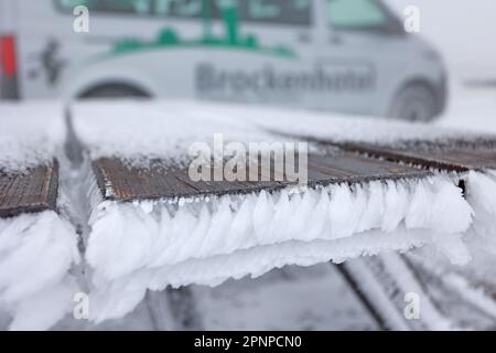 20. April 2023, Sachsen-Anhalt, Schierke: Die Tische und Bänke eines Restaurants im Freien am Brocken sind schneebedeckt. In der Nacht kehrte der Winter vorübergehend in die Harz-Berge zurück. In Gipfelbereichen gibt es eine geschlossene Schneeabdeckung. In den kommenden Tagen wird es immer wärmer sein. Foto: Matthias Bein/dpa Stockfoto