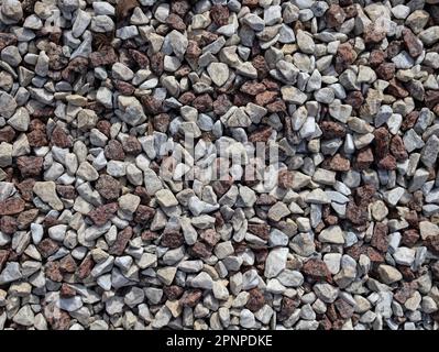 Nahaufnahme der nahtlosen Kies-Textur. Graue und braune Kiessteine für die Bauindustrie kleine Steine Kieshintergrund, Dekoration in der Garde Stockfoto