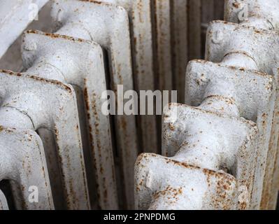 Weiße, alte Gusseisenbatterien sind nah dran. Alte gusseiserne Zentralheizungsbatterie. Metallschrott und Recyclingmaterial. Lieferung von Schrott, Ersatz von Th Stockfoto