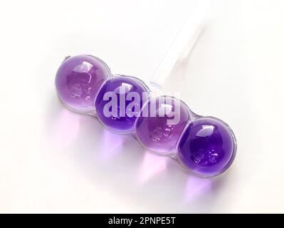 Farbige Kugeln für die Toilette auf weißem Hintergrund. Toilettenblock aus Gel, der unter dem Rand der Toilettenschüssel befestigt ist. Hängeverbindung Stockfoto