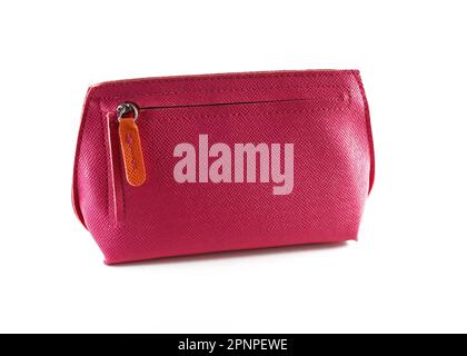Rote Lederkosmetiktasche mit Reißverschluss auf weißem Hintergrund. Rosa Nahaufnahme der Brieftasche. Eine kleine, helle Frauenhandtasche. Elegante Kosmetiktasche Stockfoto