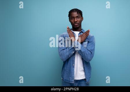 Eleganter afrikanischer Mann mit Afro-Locken, mit Leugnen-Geste auf blauem Hintergrund und Kopierbereich Stockfoto