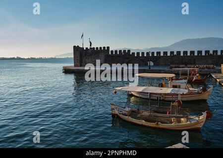 Blick auf den Fischereihafen der mittelalterlichen Stadt Nafpaktos bei Sonnenaufgang im Frühling Stockfoto