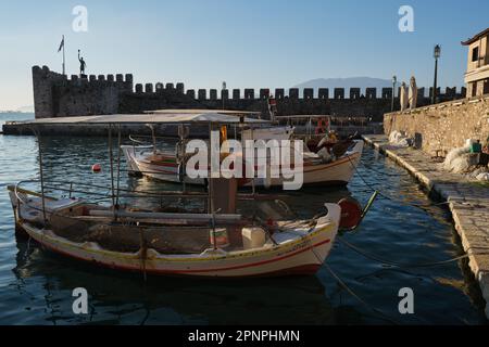 Blick auf den Fischereihafen der mittelalterlichen Stadt Nafpaktos bei Sonnenaufgang im Frühling Stockfoto