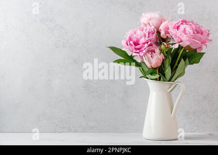 Pinkfarbener Blumenstrauß in Vase auf weißem Hintergrund mit Kopierbereich. Stillleben. Frauentag- oder Hochzeitskonzept. Urlaubshintergrund Stockfoto