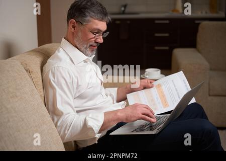 Männlich in Bürokleidung, der zu Hause arbeitet Stockfoto