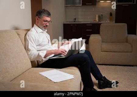 Mann in Bürokleidung, der zu Hause arbeitet Stockfoto